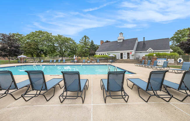 A pool surrounded by chairs with Wi-Fi at Apple Ridge Apartments, Michigan, 49534