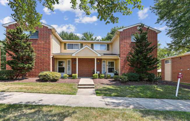 a brick house with a sidewalk in front of it