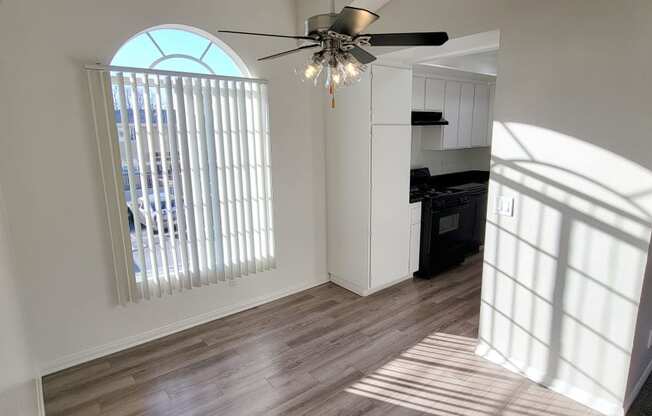 Dining room with beautiful window and ceiling fan at Northwood Apartments in Upland, California.