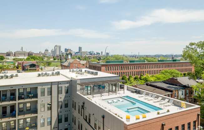 the pool on the roof of a building with a city in the background