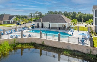 A pool with a water slide and a building in the background at Mode at Melbourne, LLC Apartments, Melbourne, FL
