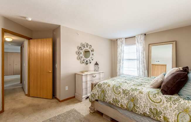 A bedroom with a bed, dresser, and mirror.