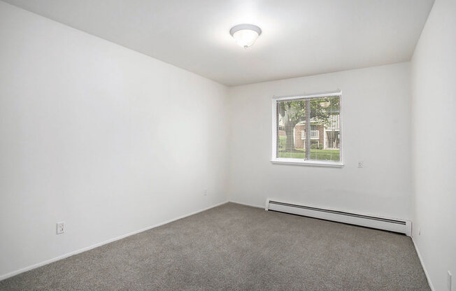 Large bedroom with carpet and a window