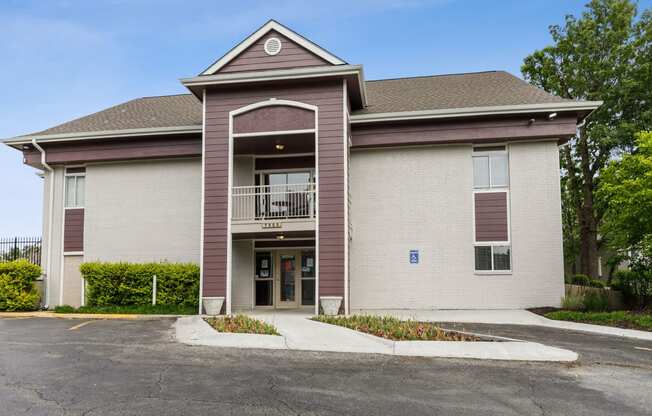 the front of a building with a balcony and a parking lot at Eastwood Crossings, Kansas City, 64129