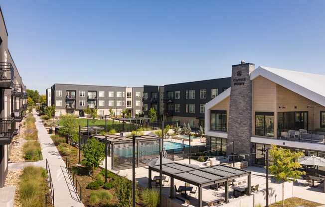 a rendering of a building with a pool and patio area with tables