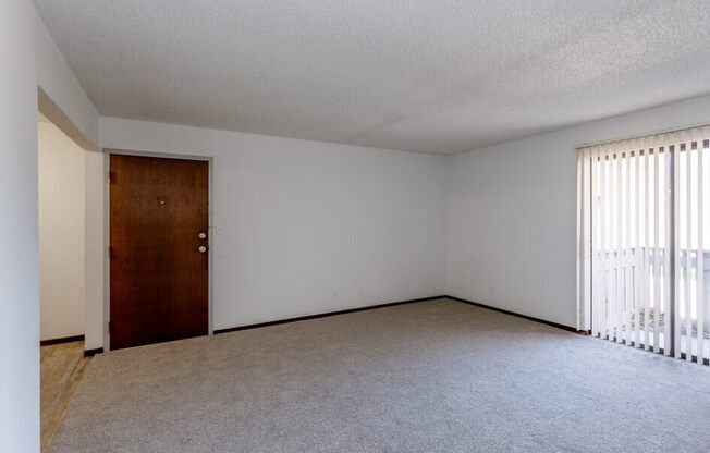 an empty bedroom with a door leading to a balcony