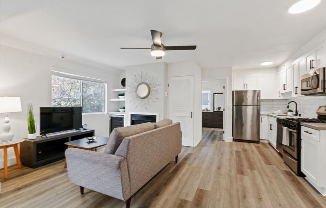 a living room and kitchen with a couch and a tv