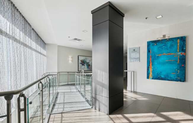 the lobby of a building with stairs and a blue painting