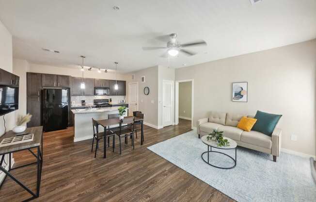 A modern living room with a kitchen in the background.
