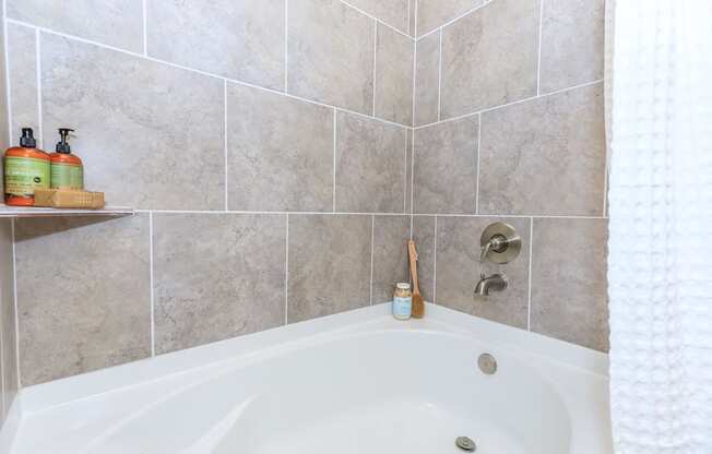 a bathroom with a bath tub and tiled walls