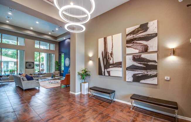 A living room with a brown floor and a large painting on the wall.