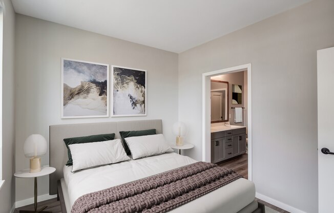 a bedroom with a large bed and a bathroom in the background