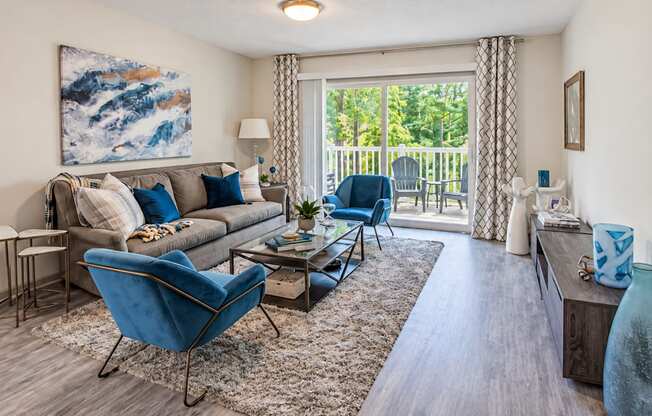 Furnished living room with sliding glass doors opening to a balcony at Icon Avondale Apartments in Decatur, GA.