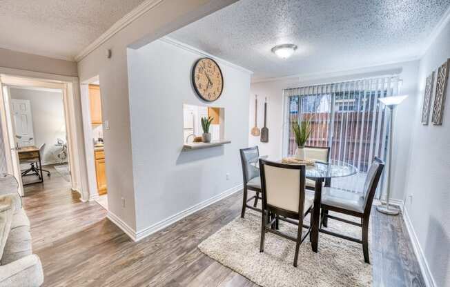 a dining room with a table and chairs and a clock on the wall