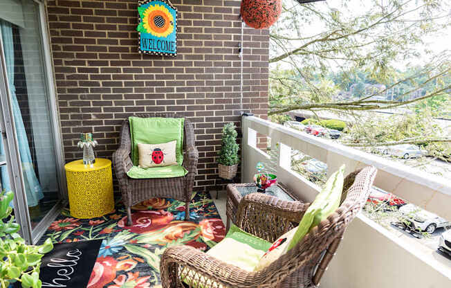 A patio with a chair and a table with a yellow tablecloth.