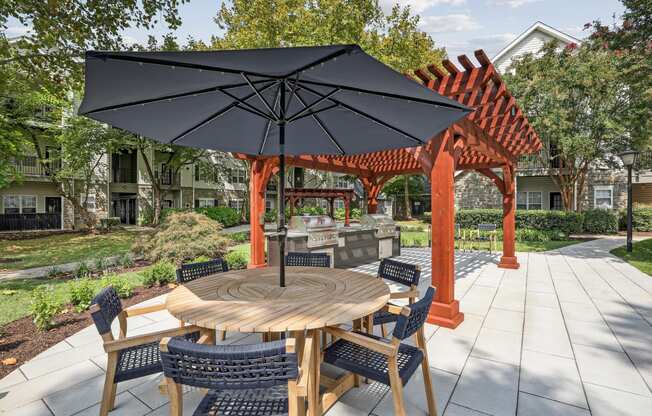 a patio with a table and chairs and umbrellas