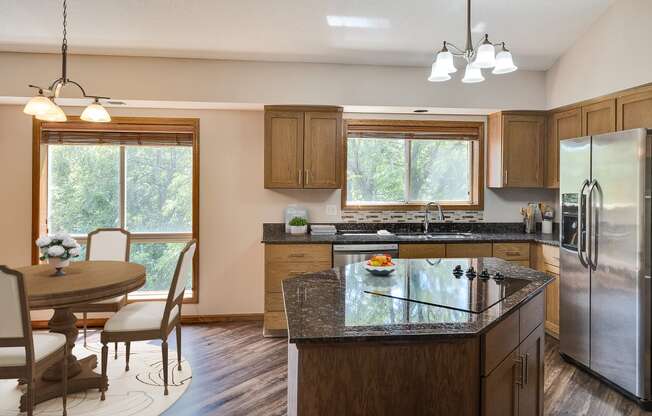 a kitchen with a island and a dining room with a table and chairs