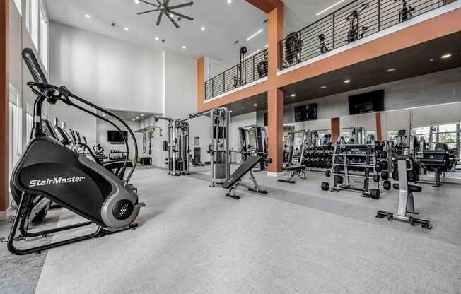 a gym with weights and cardio equipment in the lobby of a building