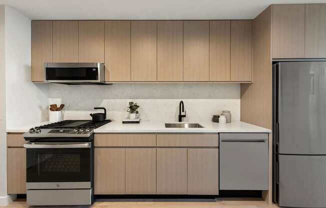 a kitchen with wooden cabinets and stainless steel appliances at The Paxton, New york