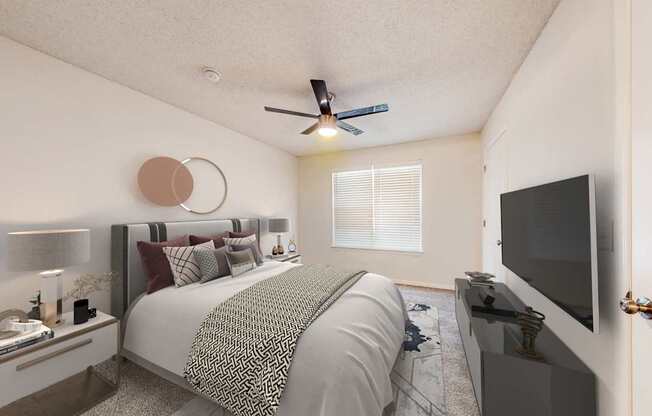 A bedroom with a bed, a television, and a ceiling fan.