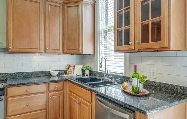 A kitchen with wooden cabinets and a granite countertop.