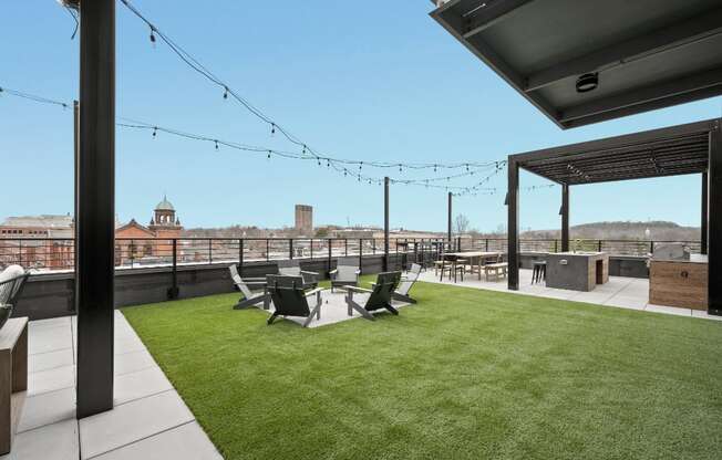 the roof terrace of a building with a lawn and chairs