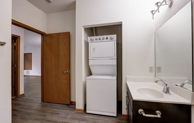 a bathroom with a washer and dryer and a sink and a laundry room