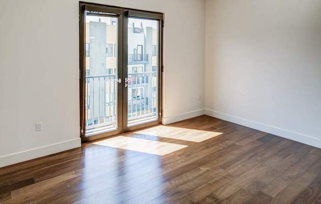 A room with a wooden floor and a sliding glass door.