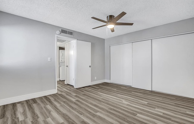 a bedroom with two closets and a ceiling fan