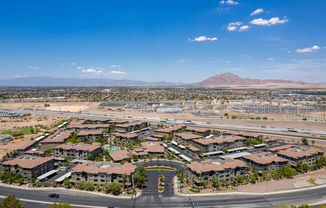 an aerial view of a neighborhood with a road and mountains in the background