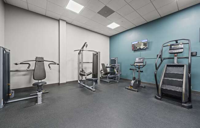 a large room with exercise equipment and a wall mounted tv  at The Icon, Richmond, 23230