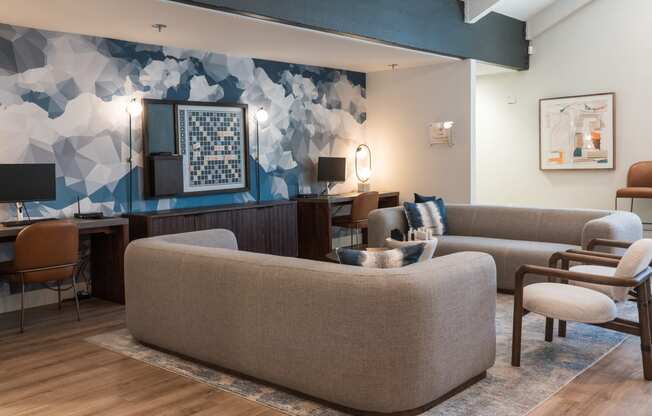 a living room with couches chairs and a desk in a hotel room