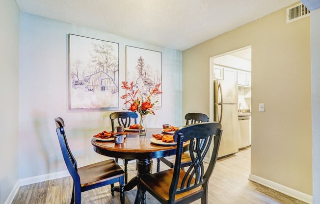 a dining room with a wooden table and chairs