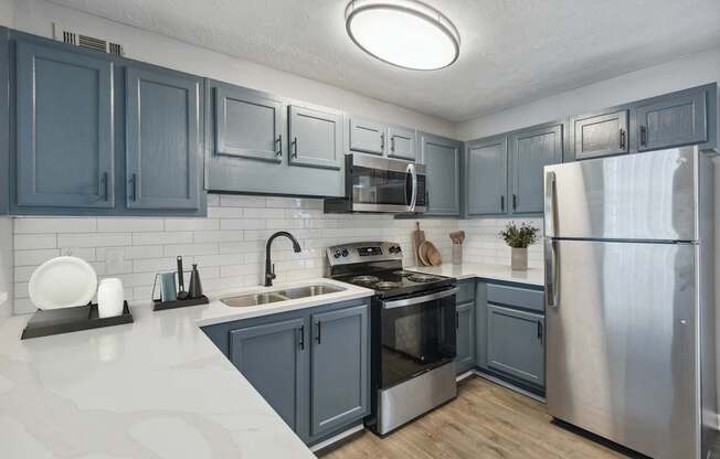 A kitchen with a stove top oven and a refrigerator.