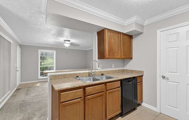 A kitchen with wooden cabinets and a black dishwasher.