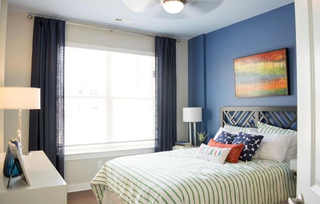 a bedroom with blue walls and a bed with striped pillows at GrandView Flats and Townhomes, Indiana, 46530