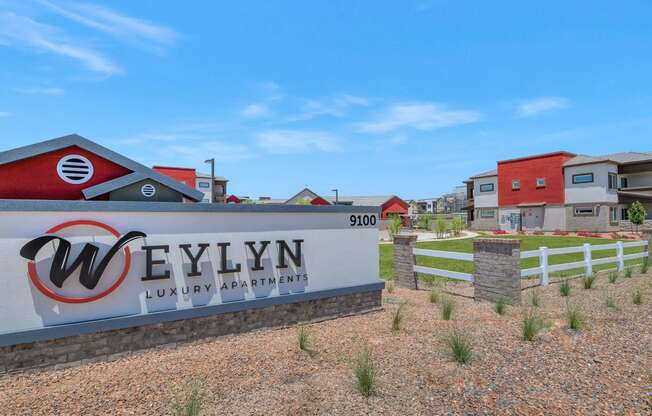 a sign luxury apartments with houses in the background at Weylyn Luxury Apartments, Laveen, Arizona