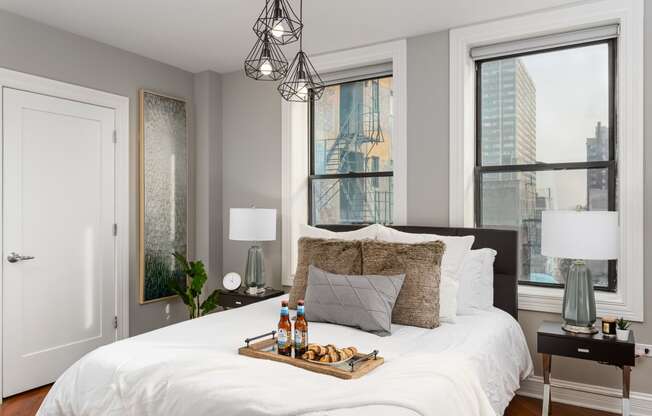 a bedroom with a large bed and two windows