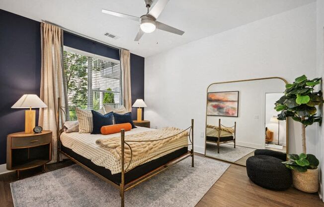 a bedroom with a bed in a room with a large window at Link Apartments® 4th Street, Winston-Salem, 27101