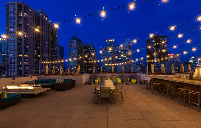 a rooftop bar with a view of the city at night