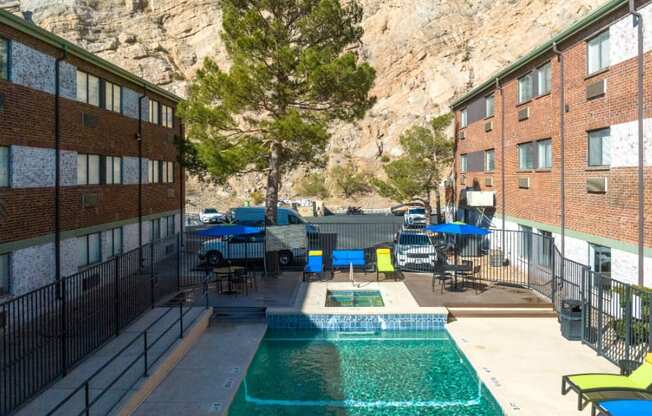 the pool is next to a building with a mountain in the background
