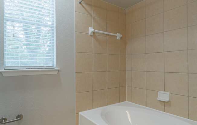 an empty bathroom with a tub and a window