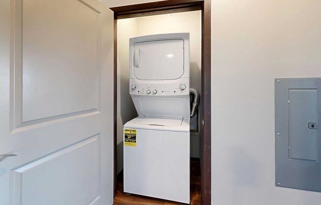 A stacked full size washer and dryer in a closet.