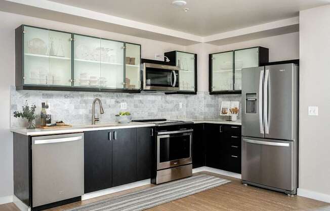 a kitchen with stainless steel appliances and black and white cabinets