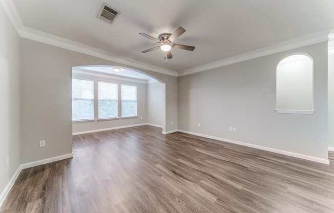 a living room with hardwood floors and a ceiling fan