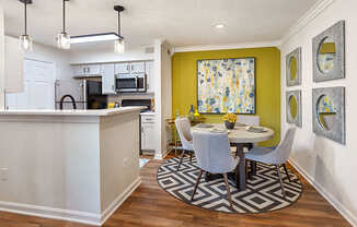 A kitchen with a dining table and chairs in the middle of the room.