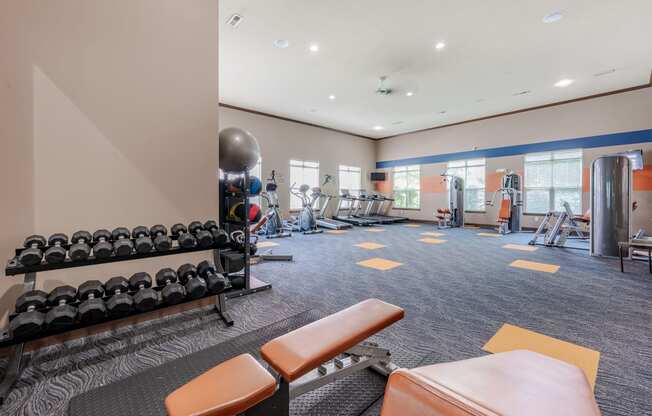 spacious gym with weights and cardio equipment at the reserve apartments