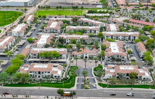 an aerial view of a suburb of a city with cars on the street and houses