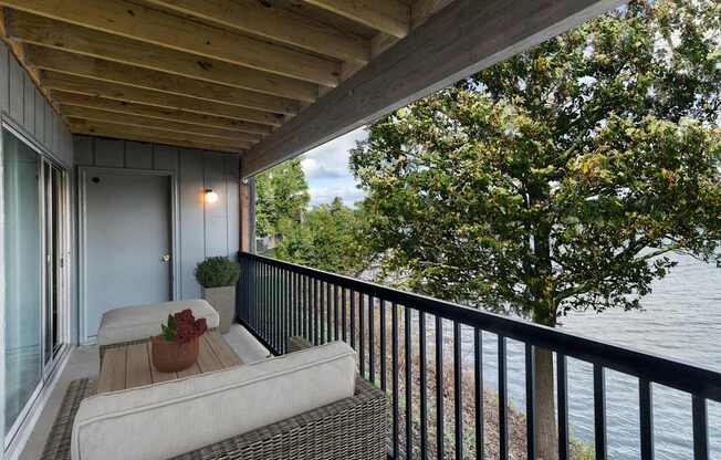 A balcony with a couch and a view of the water.