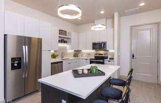 a kitchen with stainless steel appliances and quartz counter tops at Zeta Luxury Apartments in Sacramento, CA